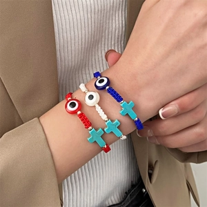 Detaillierte Makroansicht von gewebten Evil Eye und Türkis-Kreuz-Armbändern an einem Modell