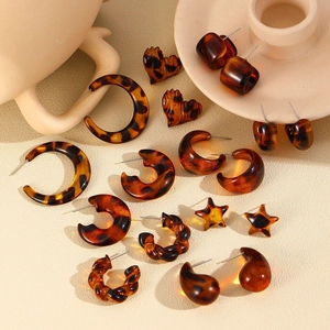 Macro view of vintage leopard print resin earrings set including C-shape and heart studs
