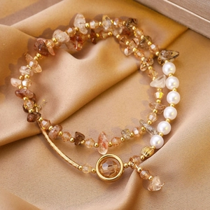 Détail d'un bracelet vintage à plusieurs rangs avec cristaux bruns, perles et breloque
