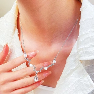 Detail of silver antler necklace with white pearls and a teardrop-shaped zircon pendant