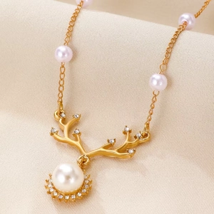 Detail of elegant gold antler necklace with a white pearl and sparkling rhinestones