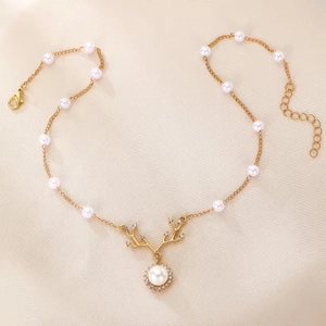 Detail of antler pendant featuring white pearls and crystals on a fine gold-tone chain