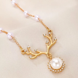 Detailed macro view of the antler pendant featuring white pearls and sparkling rhinestones