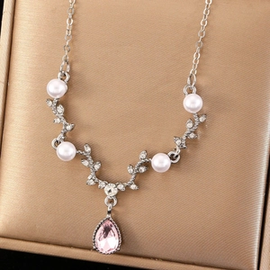 Elegant antler necklace with pearls and pink teardrop gemstone on a jewelry box