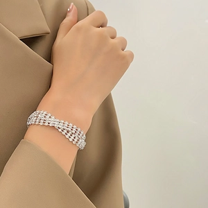 Detalle de la pulsera de cuatro filas de diamantes de imitación con una chaqueta elegante
