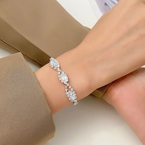 Detalle macro de la pulsera trenzada plateada con pedrería de corte marquesa en la muñeca