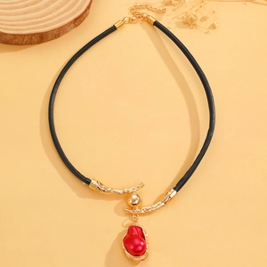 Detail van vintage lederen ketting met rode barokke parelhanger in een gouden frame