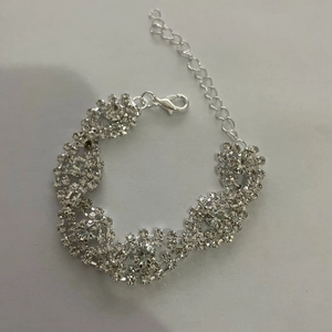 Primer plano de pulsera trenzada con diamantes de imitación y cierre de mosquetón