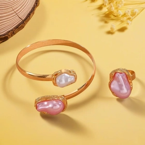 Detailsicht auf gehämmertes Gold-Armreif- und Ring-Set mit rosa und weißen Perlen