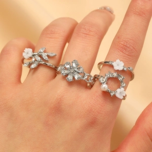 Ensemble de quatre bagues argentées avec fleurs 3D blanches et cristaux pour femme