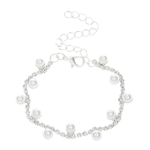 Detalle de pulsera tejida de pedrería plateada con perlas y cierre de mosquetón ajustable