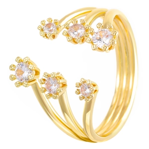 Macrodetail van de drielaagse gouden ring met zes fonkelende stenen in bloemvormige zetting