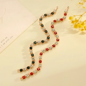 Detalle de pulseras de ondas doradas con diamantes de imitación rojos, verdes y blancos