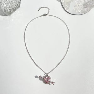 Detail eines rosa herzförmigen Kristallanhängers mit Pfeil und verstellbarer Silberkette