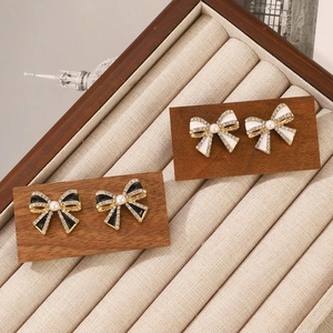 Details von Vintage-Ohrringen im französischen Stil mit Perlen und Strass auf Holz