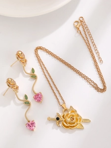Nahaufnahme der Gothic-Rose und Herz-Schwert-Halskette mit rosa Steinen und Goldfinish