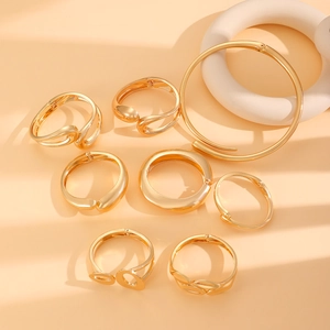 Detail of geometric gold cuffs and choker with high-polish finish on artful backdrop