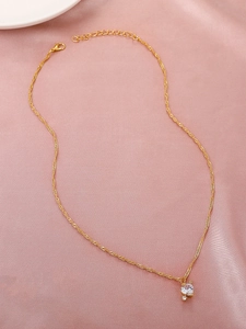 Nahaufnahme der goldenen Herz-Halskette mit Kristall-Pfeil auf elegantem rosa Satin