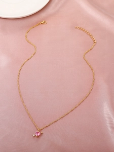 Detailansicht der rosa Herz-Halskette mit goldener Kette auf rosa Seidenhintergrund