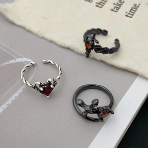 Detailed view of gothic punk rings with red heart gemstone and black rose cross designs