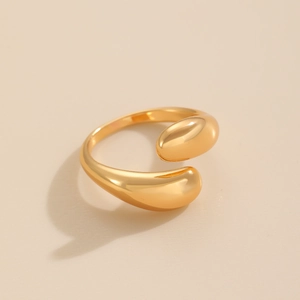 Detailed view of golden open cuff ring with polished waterdrop ends and smooth finish