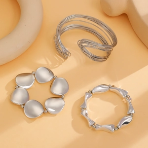 Detailed macro shot of three silver geometric minimalist bracelets with mirror finish