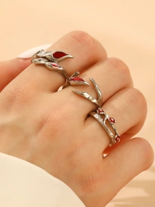 Detailed macro view of silver punk rings with red gemstone accents and fluid flame designs