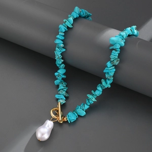 Detail of turquoise bead necklace with golden OT clasp and large baroque pearl pendant