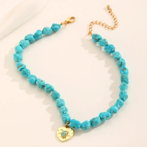 Bohemian turquoise beaded necklace with golden heart pendant and evil eye detail