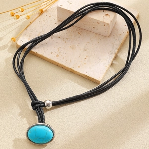 Detail of bohemian turquoise pendant necklace with black wax rope and silver beads