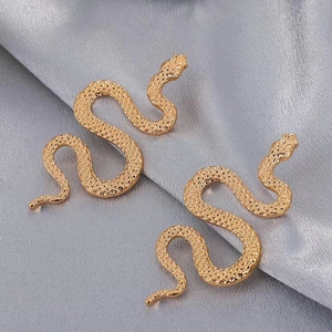 Close-up detail of golden snake jewelry with intricate scale texture on silk fabric
