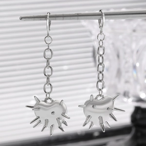 Vue macro de boucles d'oreilles cœur punk gothique avec pointes et chaîne pendante