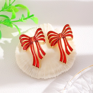 Christmas bow knot earrings in red and gold finish on coral stand for women