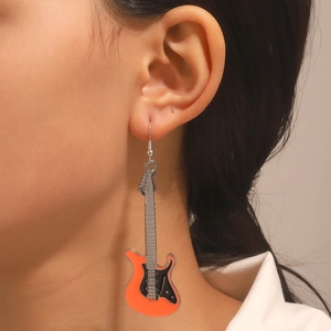 Orecchini a forma di chitarra in smalto arancione stile punk indossati da una modella