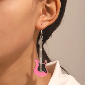 Orecchini a sospensione a forma di chitarra rosa e nera con strass su una modella