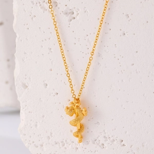 Gedetailleerde close-up van een gouden slang rond een kruisscepter hanger op getextureerde rots