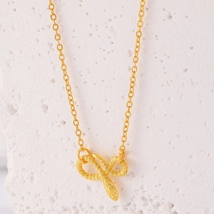Macro-opname van gouden slang-infinity hanger met schubben op witte natuursteen