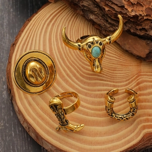 Detailansicht von Vintage-Goldringen im Western-Stil mit Bullenkopf-, Hut- und Stiefelmotiven