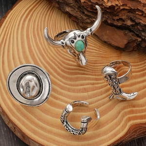 Retro-Western-Ring-Set mit Totenkopf und Stiefel-Details auf einem Holzuntergrund