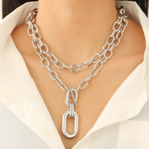 Close-up of double layer chunky silver chain necklace with oval pendant and toggle clasp