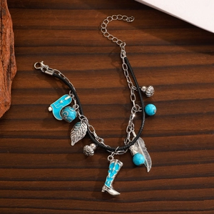 Detail einer Boho-Halskette mit blauem Stiefelanhänger und Federanhängern aus Metall