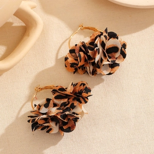 Detailed close-up of golden hoop earrings featuring leopard print fabric flower petals