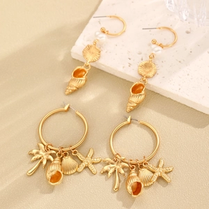 Detail of gold ocean-themed earrings featuring pearl, starfish, and seashell charms