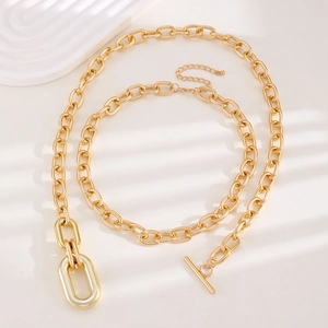 Detail of chunky gold chain necklace featuring a stylish toggle clasp and polished rings