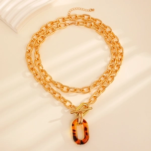 Close-up of double layer gold chain necklace with tortoise shell pendant and OT buckle