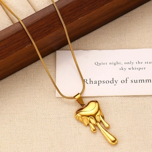 Elegant gold snake chain necklace featuring a polished lava heart pendant on fabric