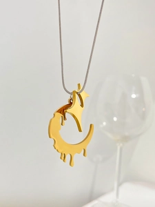 Close-up of golden fluid lava pendant on a silver snake chain showing mirror finish