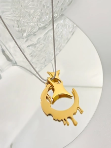 Close-up of golden lava heart pendant on silver chain resting on a vanity mirror