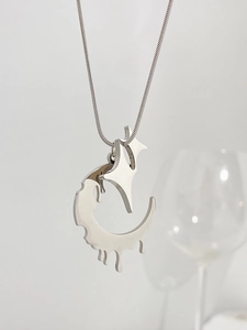 Detailed close-up of molten lava silver moon and star pendant on a snake chain