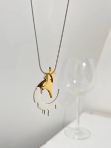 Detail of a two-tone lava heart necklace with gold star and silver melting moon pendant